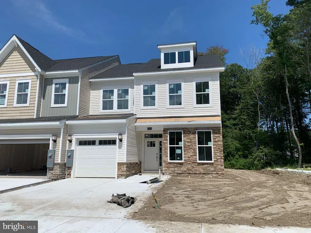 a front view of a house with yard and trees