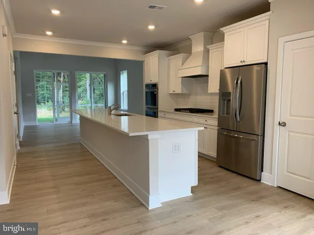 a kitchen with kitchen island a large counter top space stainless steel appliances and a large window