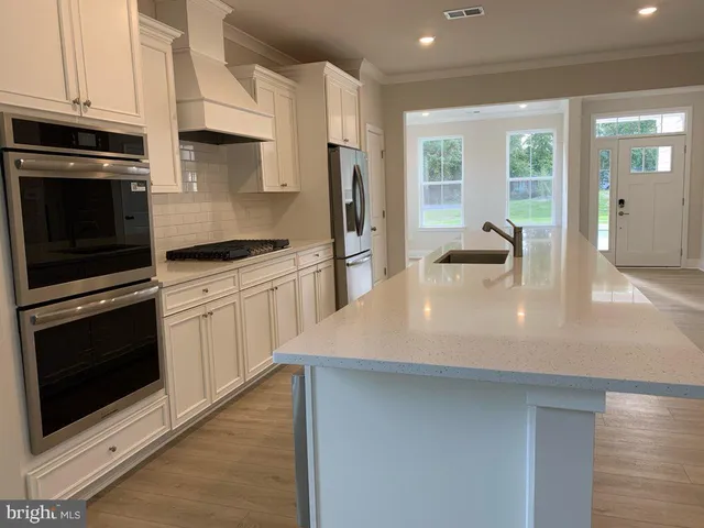 a kitchen with stainless steel appliances a stove microwave and refrigerator
