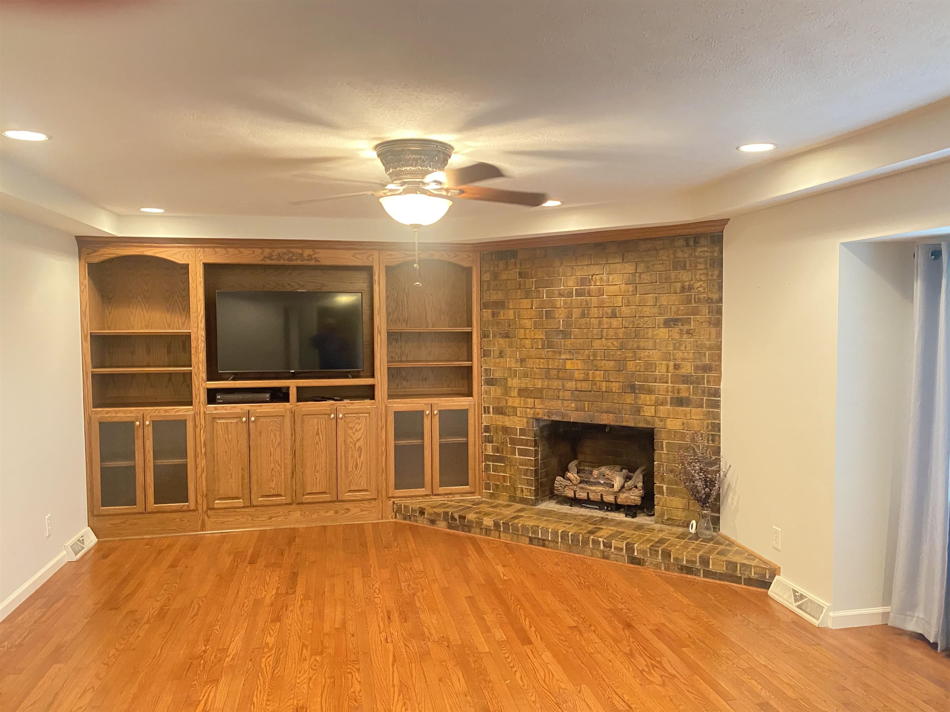 629 Hillside Drive Adamsville, TN 38310 - Photo 8 of 35 a view of an empty room with a fireplace and a window
