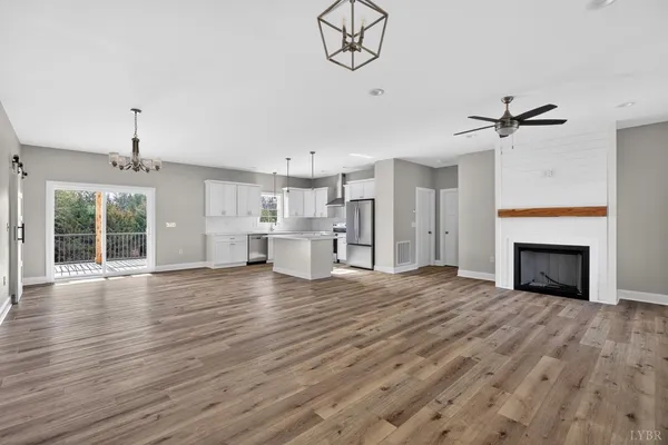 a view of empty room with wooden floor and fireplace
