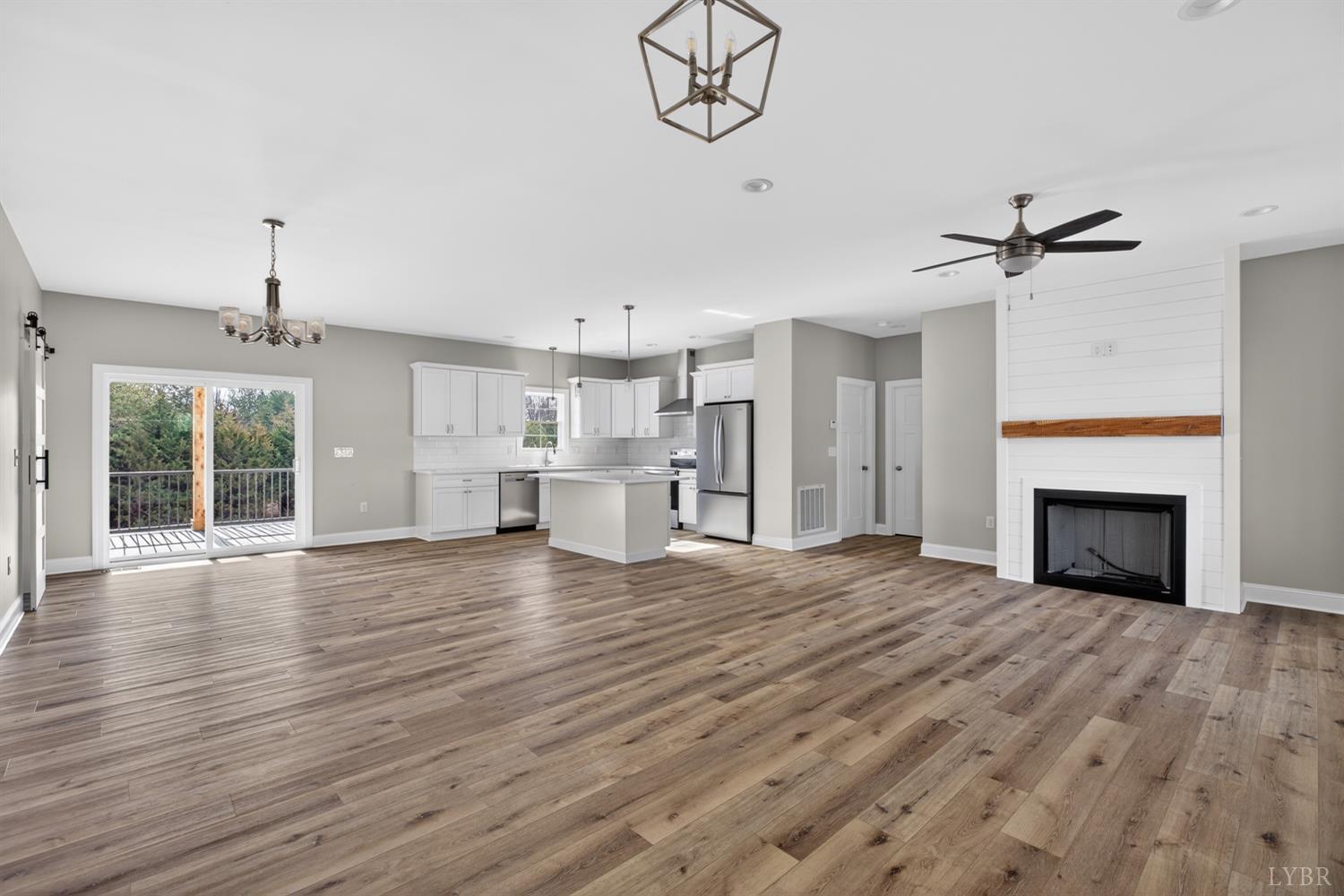 a view of empty room with wooden floor and fireplace
