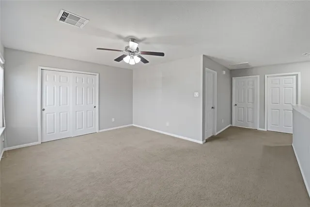 a view of an empty room with a ceiling fan