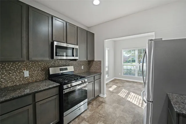a kitchen with granite countertop a stove top oven and sink