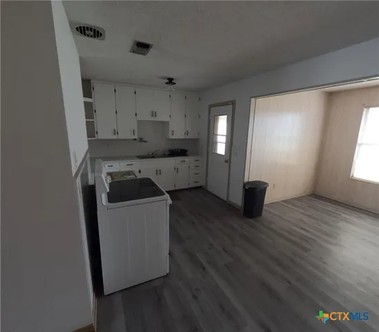 a utility room with cabinets washer and dryer