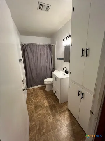 a white toilet sitting next to a bathroom sink