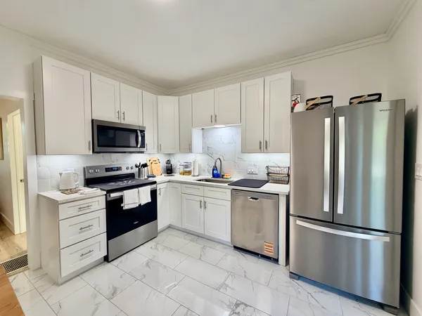 a kitchen with white cabinets and stainless steel appliances