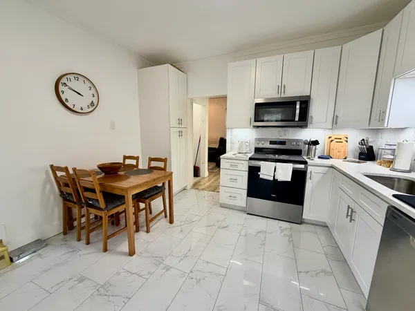 a kitchen with stainless steel appliances a stove a sink a microwave and a refrigerator