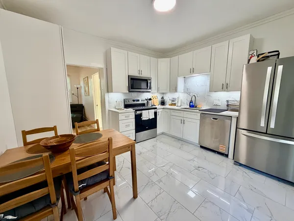 a kitchen with stainless steel appliances a stove a sink refrigerator and a table