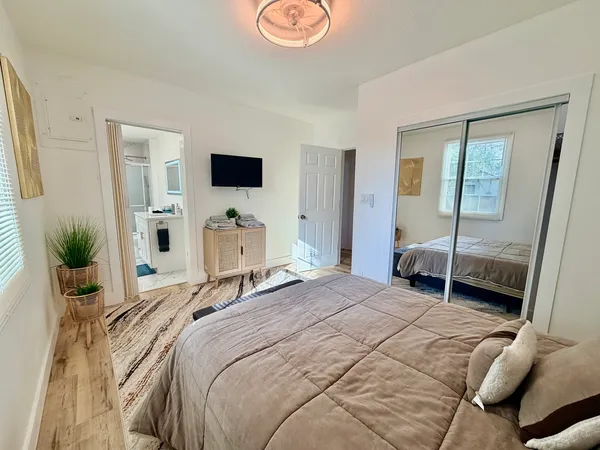 a bedroom with a bed and a flat tv screen