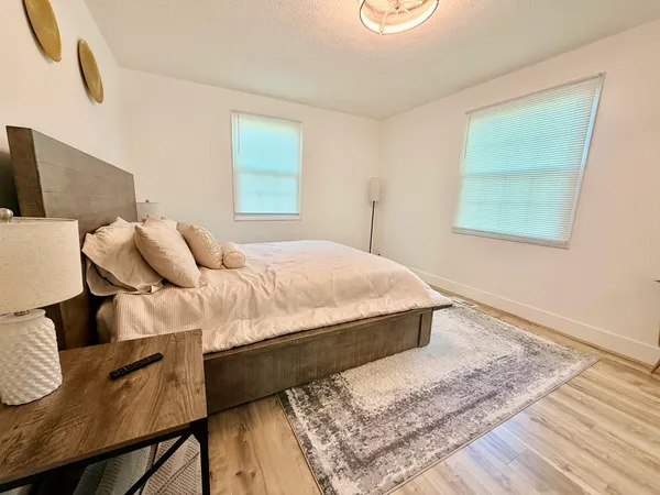 a bedroom with a bed and wooden floor