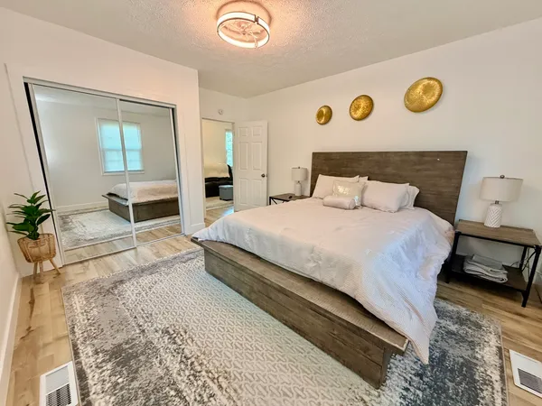 a bedroom with a bed and dresser with mirror