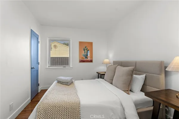 a bedroom with a bed and painting on the wall