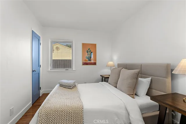 a bedroom with a bed and painting on the wall