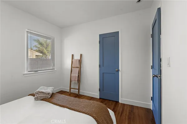 a bedroom with a bed and a painting on the wall