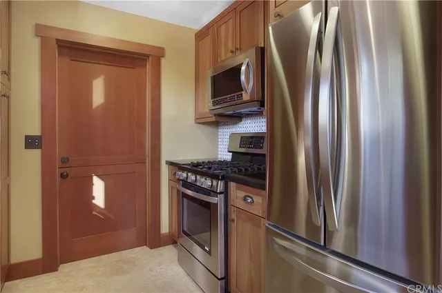 a kitchen with stainless steel appliances granite countertop a refrigerator and a sink