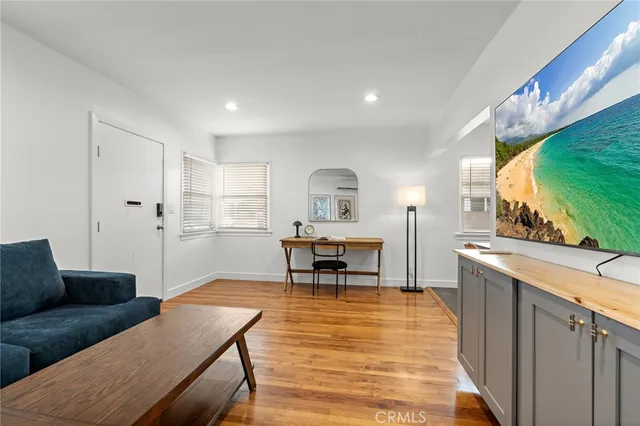 a living room with furniture and a wooden floor