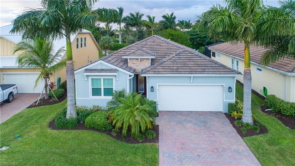 14671 Topsail Drive Naples, FL 34114 - Photo 1 of 26 a front view of a house with a garden and palm trees