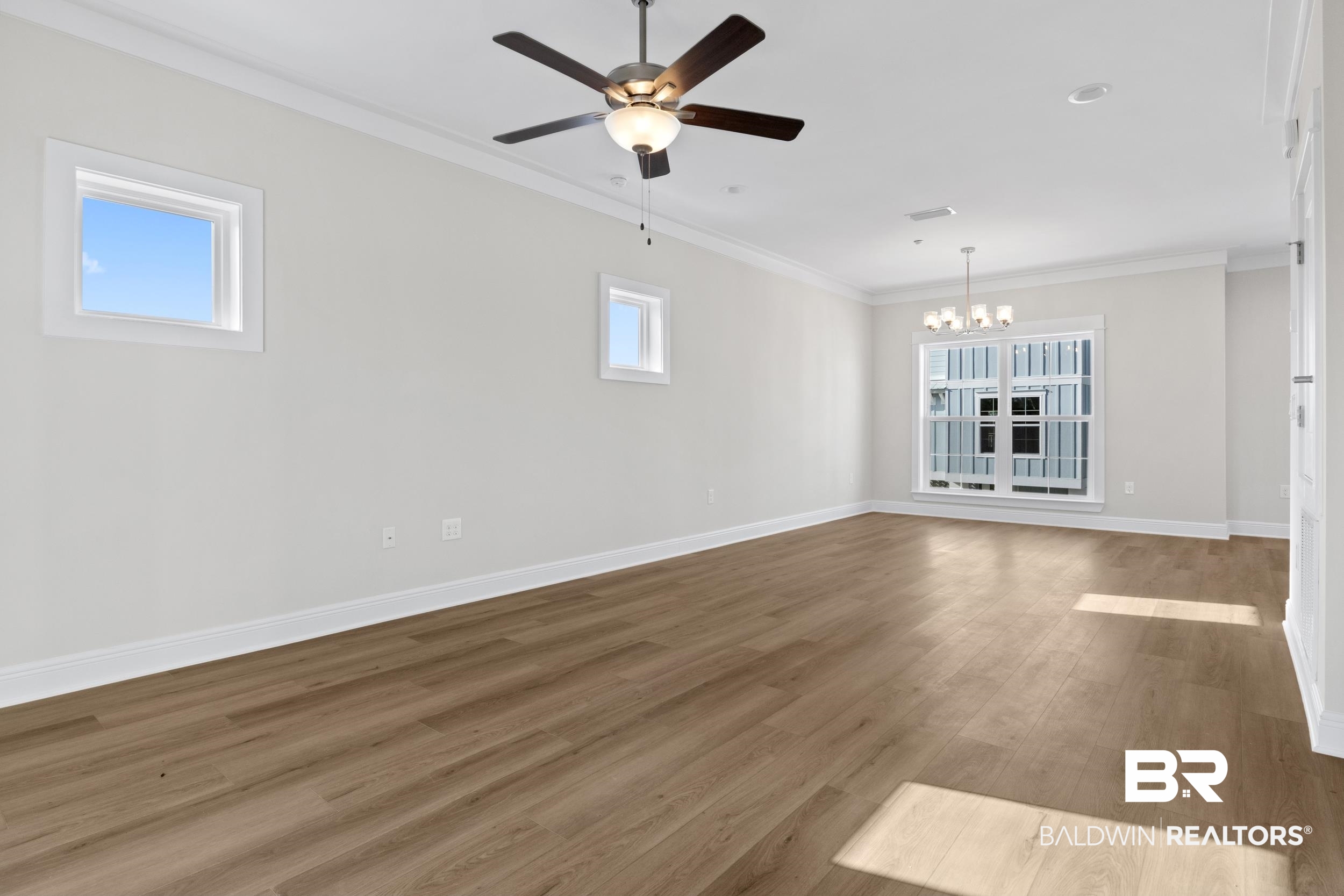2847 Salt Drive Orange Beach, AL 36561 - Photo 8 of 29 Unfurnished living room featuring hardwood / wood-style floors, ceiling fan with notable chandelier, and ornamental molding