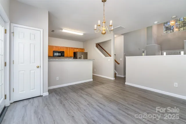 a view of a livingroom with wooden floor and chandelier