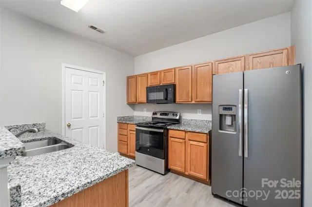 a kitchen with granite countertop stainless steel appliances and wooden cabinets