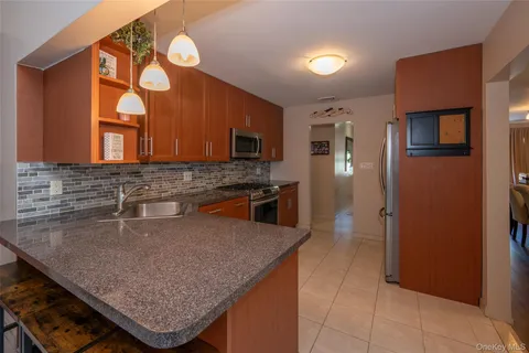 a kitchen with stainless steel appliances granite countertop a sink a microwave and wooden cabinets