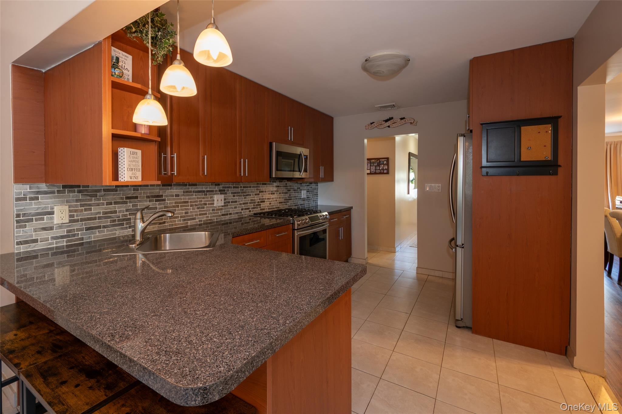 211 Gardner Avenue Jericho, NY 11753 - Photo 15 of 36 a kitchen with stainless steel appliances granite countertop a sink a microwave counter space and cabinets