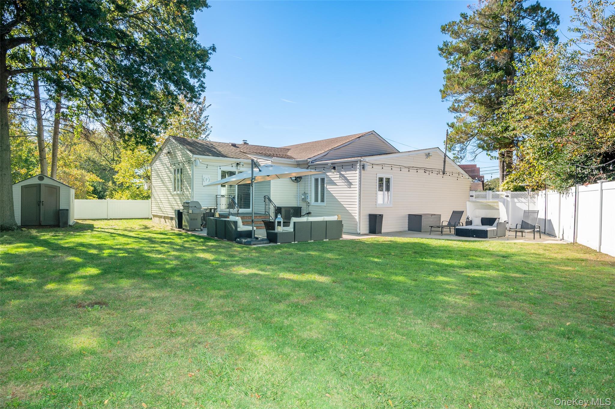 211 Gardner Avenue Jericho, NY 11753 - Photo 30 of 36 a view of a white house in front of a big yard with large trees