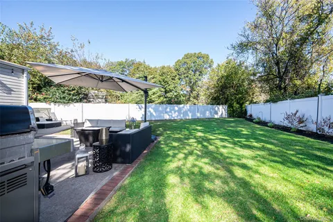 a view of a backyard with table and chairs potted plants and a palm tree