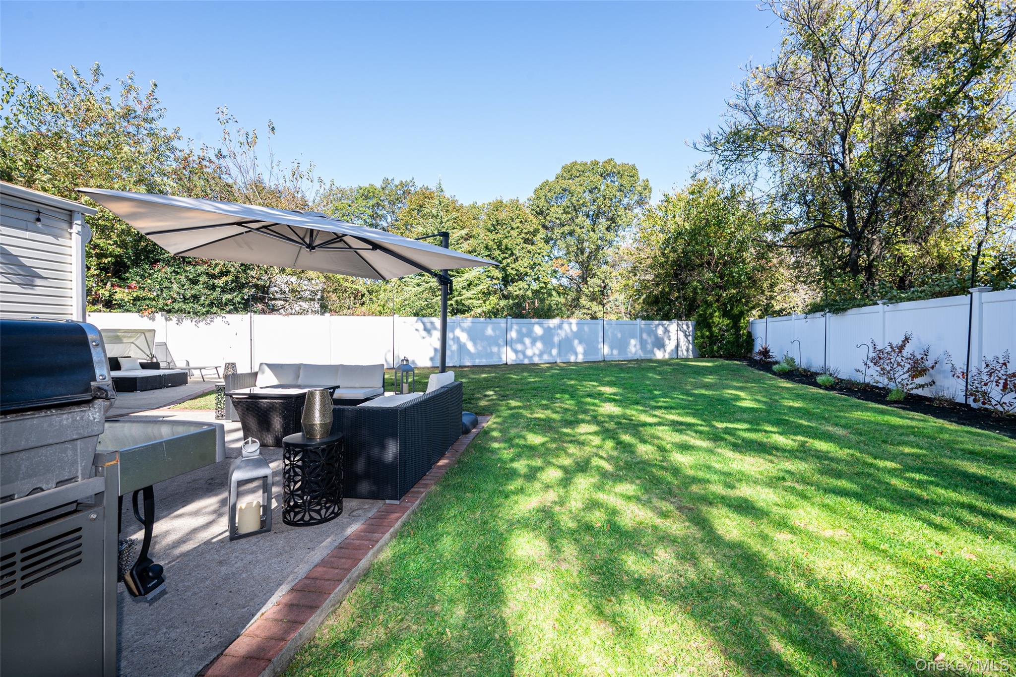 211 Gardner Avenue Jericho, NY 11753 - Photo 32 of 36 a view of a backyard with table and chairs potted plants and a palm tree