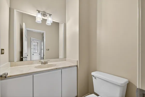 a bathroom with a toilet a sink and mirror