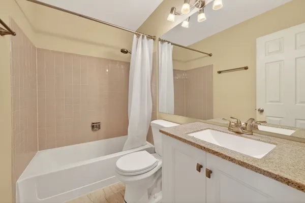a bathroom with a granite countertop sink mirror vanity and toilet