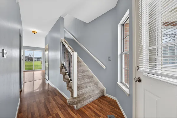 a view of entryway and hall with wooden floor
