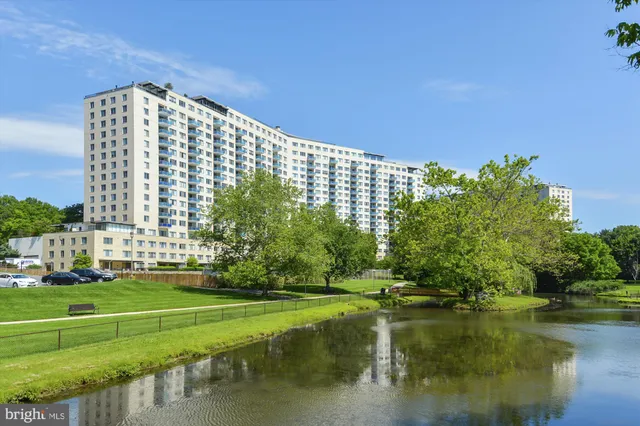 a view of a large building with a garden and trees