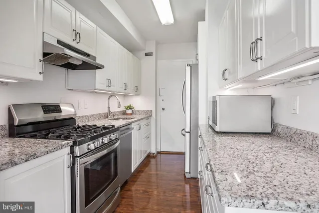 a kitchen with stainless steel appliances granite countertop a stove a sink and a refrigerator