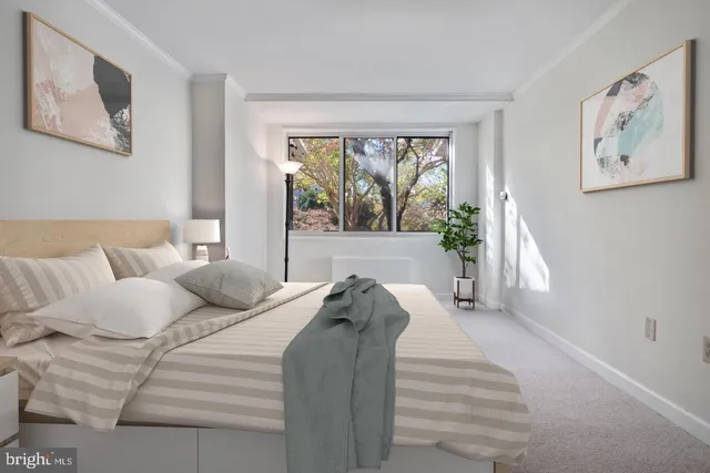 a bed sitting in a bedroom next to a window