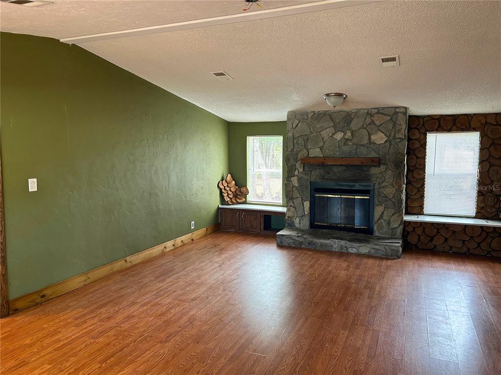 9867 Jerome Drive New Port Richey, FL 34654 - Photo 6 of 30 a view of a livingroom with wooden floor and a fireplace