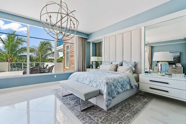 a bedroom with a bed chandelier and window