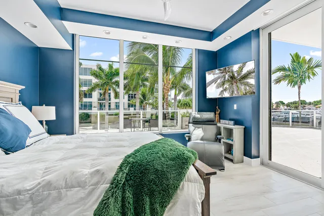 a large bedroom with a large bed and a large window with balcony view