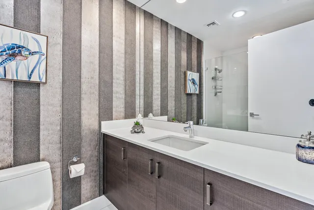 a bathroom with a sink a toilet and a mirror