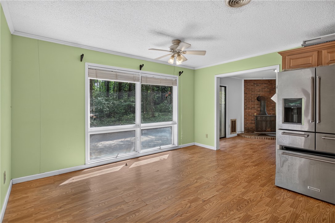 123 Robin Road Westminster, SC 29693 - Photo 23 of 50 A spacious room offers ample natural light from expansive windows, complemented by a ceiling fan for comfort.