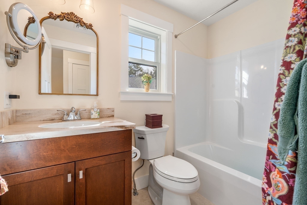 69 Abbey Road, Unit 69 Westwood, MA 02090 - Photo 13 of 16 a bathroom with a granite countertop sink toilet mirror vanity and bathtub