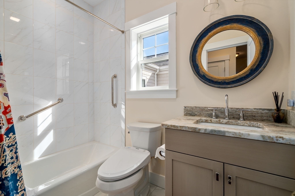 69 Abbey Road, Unit 69 Westwood, MA 02090 - Photo 10 of 16 a bathroom with a granite countertop toilet a sink and a mirror
