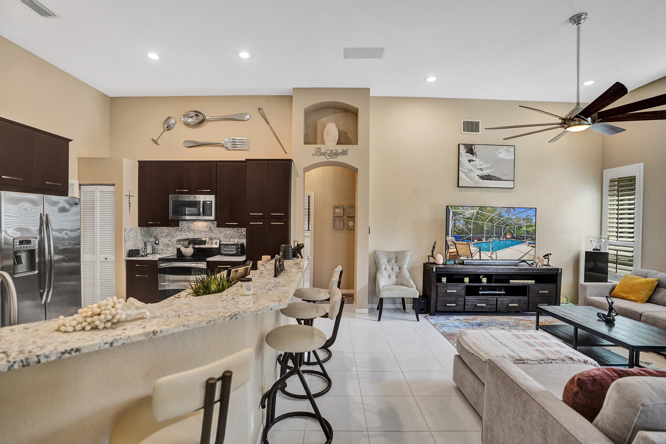 10063 Umberland Place Boca Raton, FL 33428 - Photo 20 of 97 a living room with furniture a flat screen tv and kitchen view