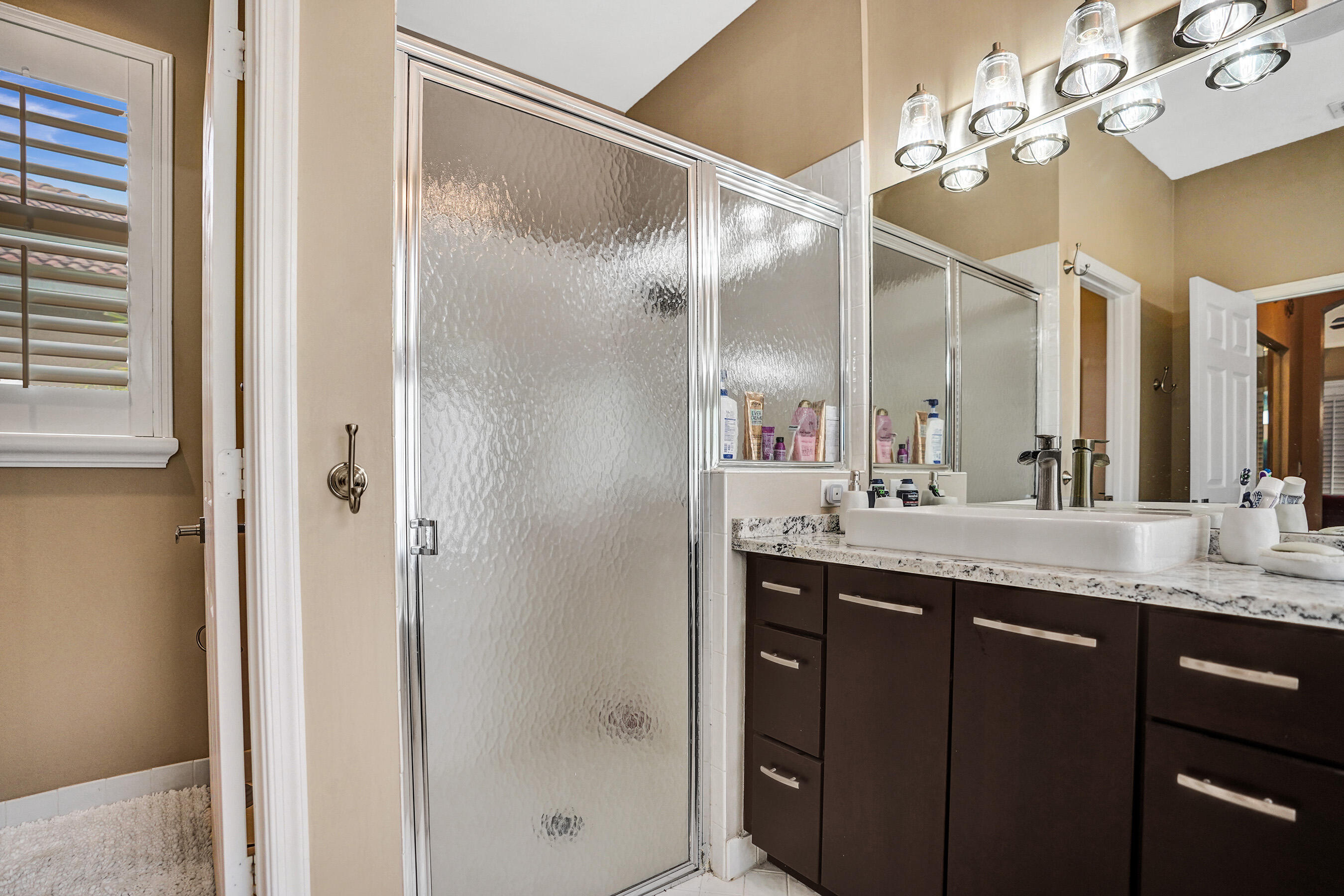 10063 Umberland Place Boca Raton, FL 33428 - Photo 48 of 97 a bathroom with a granite countertop sink a mirror and a shower