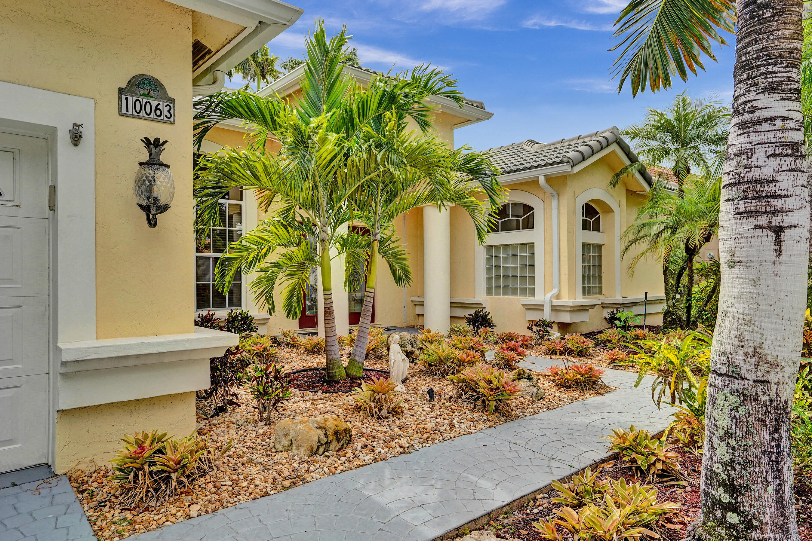 10063 Umberland Place Boca Raton, FL 33428 - Photo 67 of 97 a front view of a house with a garden