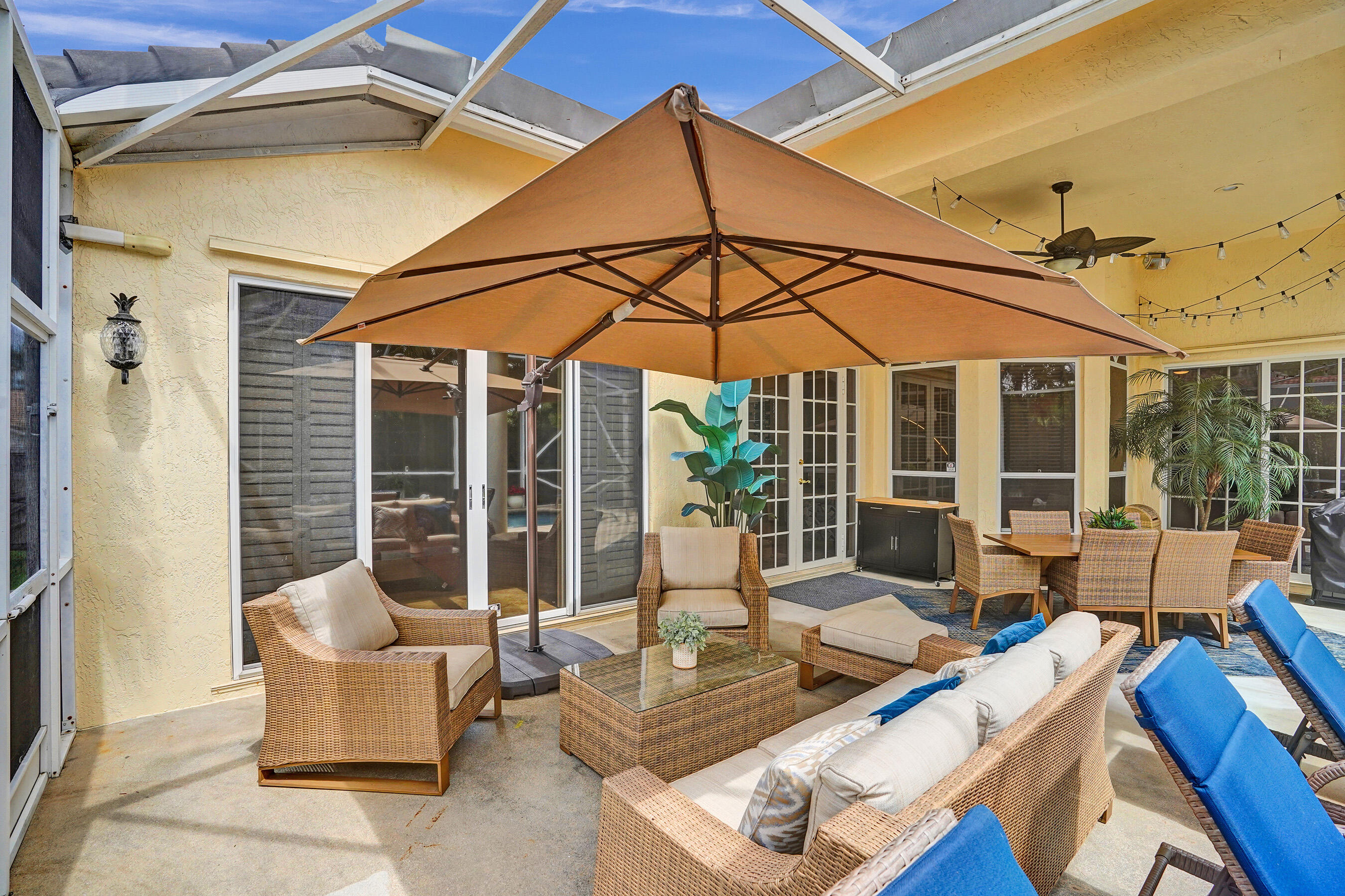 10063 Umberland Place Boca Raton, FL 33428 - Photo 85 of 97 a view of a patio with couches table and chairs under an umbrella