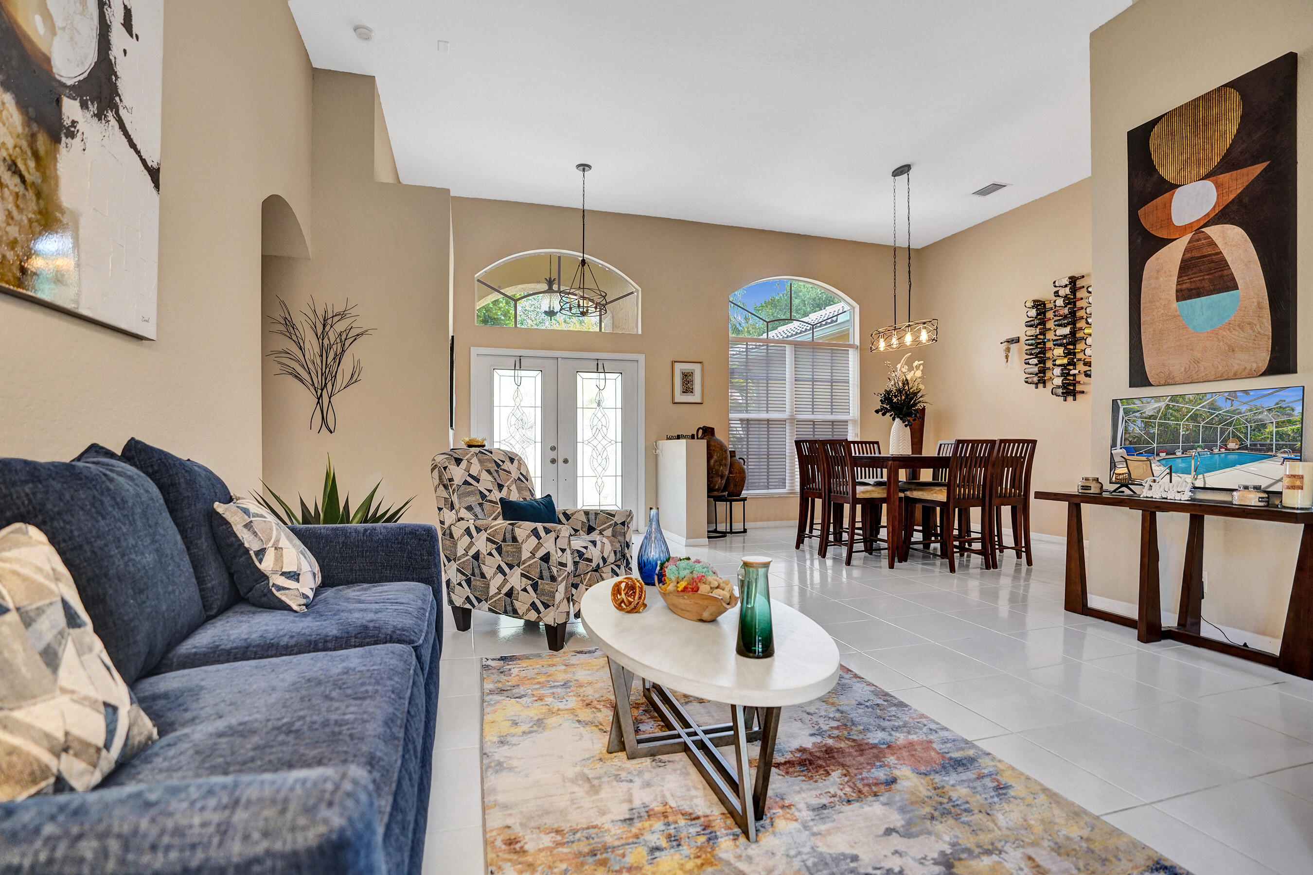 10063 Umberland Place Boca Raton, FL 33428 - Photo 10 of 97 a living room with furniture a dining table and a chandelier