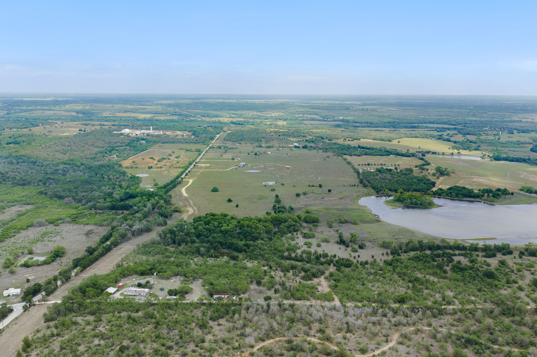 Lot 16 Mineral Springs Road Lockhart, TX 78644 - Photo 4 of 7 Expansive aerial landscape featuring a large body of water, scattered structures, and diverse tree coverage