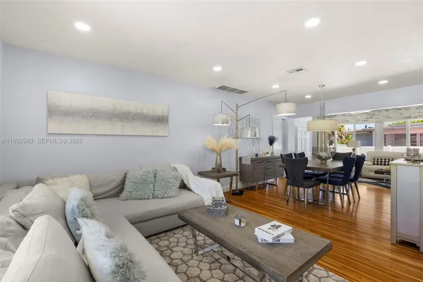 a living room with furniture and a wooden floor